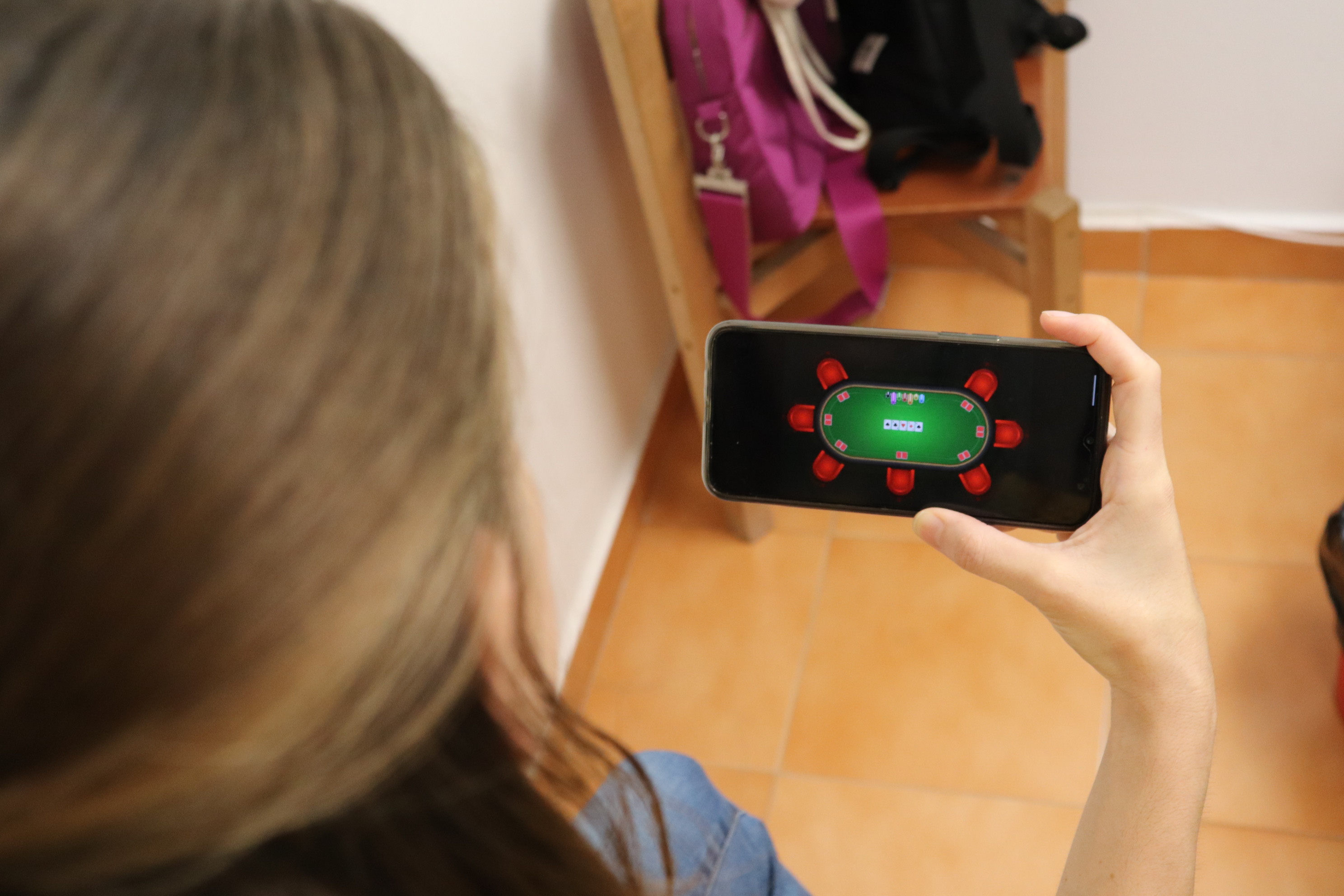 Una joven ve un juego de azar en la pantalla de su móvil