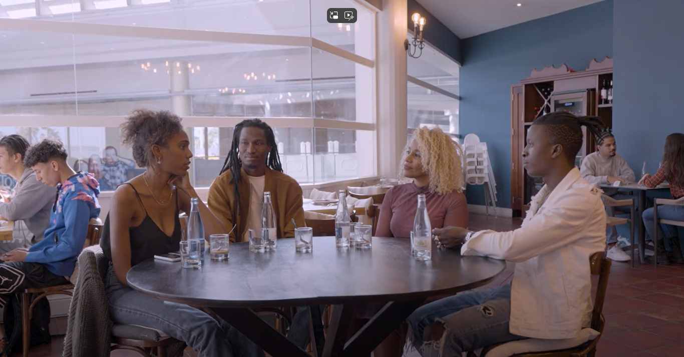 Cuatro personas protagonistas del documental conversan en torno a una mesa