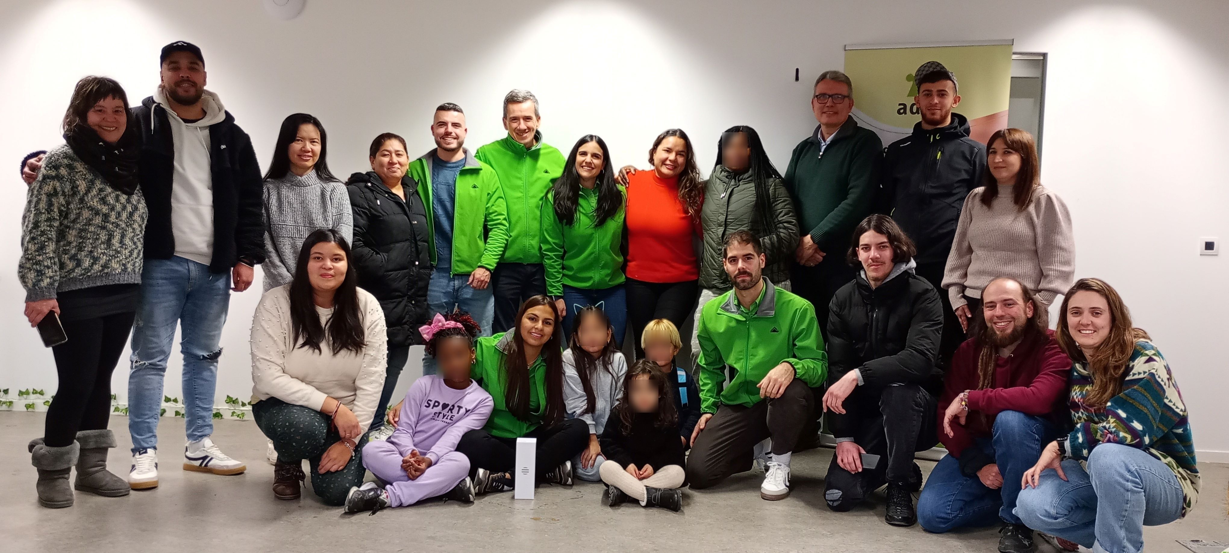 Un grupo de personas adultas y niños y niñas posando para la foto. Algunos van vestidos con el uniforme de Leroy Merlin