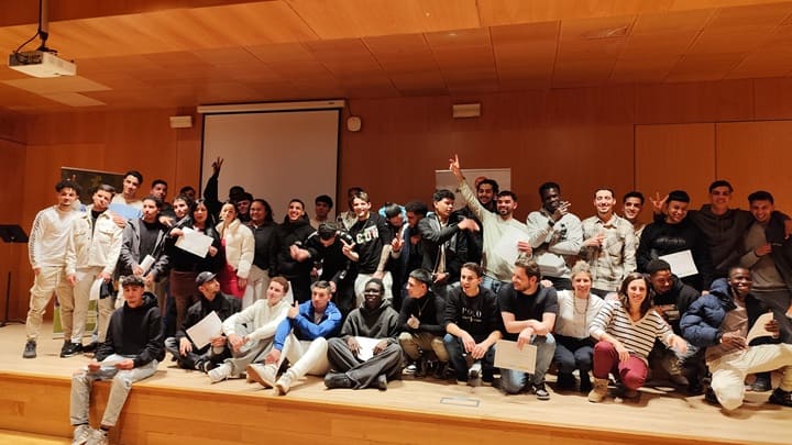 Imagen de los y las asistentes al acto de graduación celebrando en el escenario