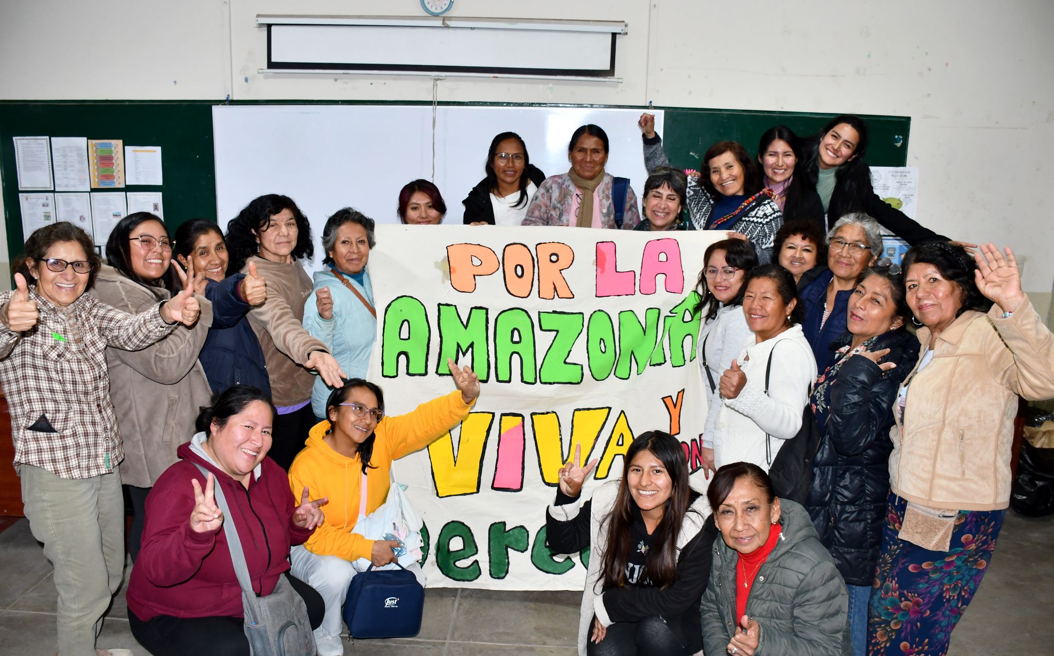 Un grupo de mujeres posando con una pancarta en la que se lee: Por la Amazonia viva y verde