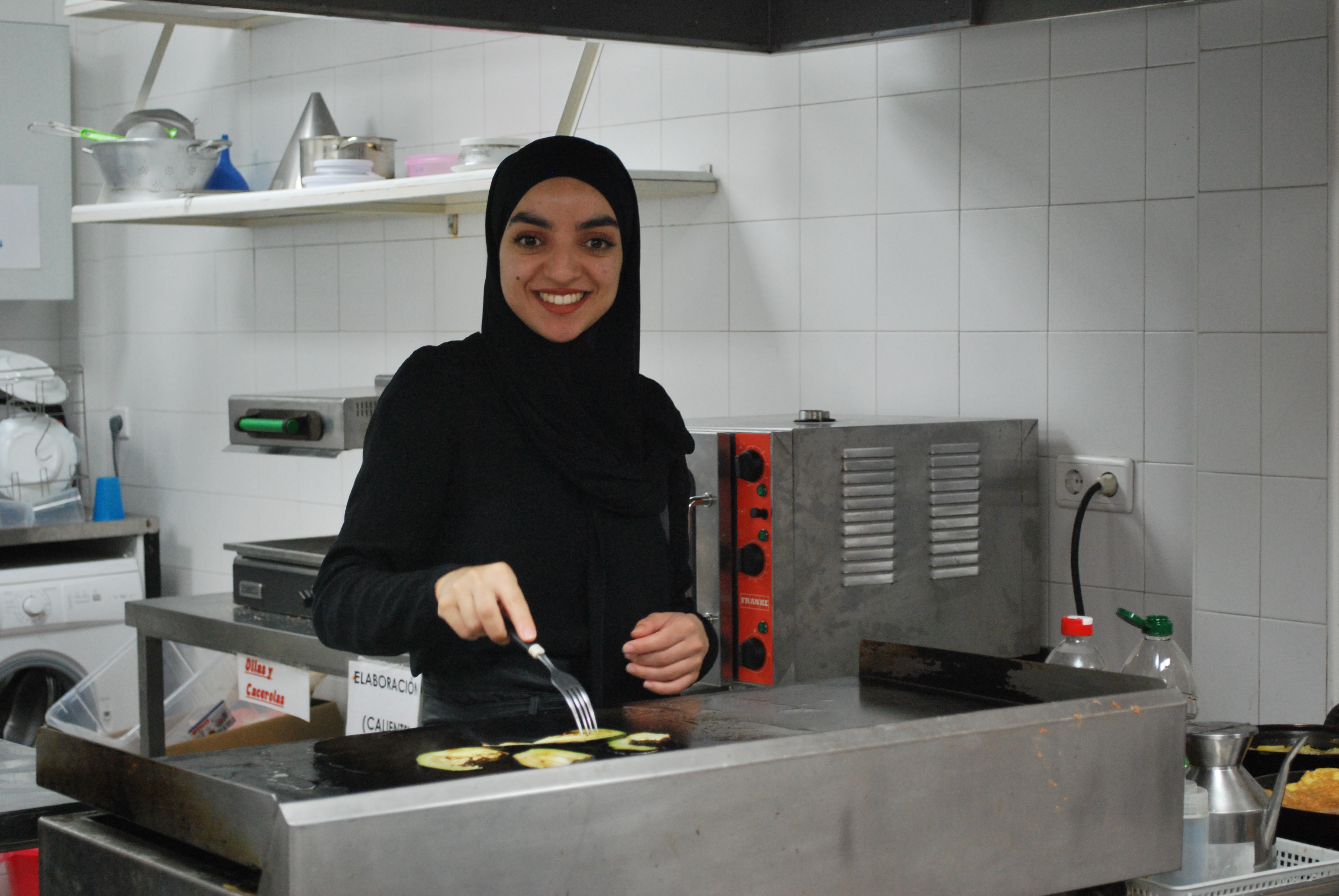 Una chica cocinando y sonriendo