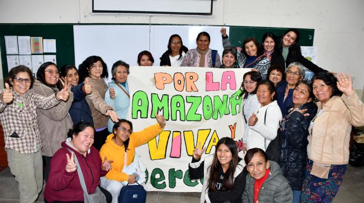 Un grupo de mujeres posando con una pancarta en la que se lee: Por la Amazonia viva y verde