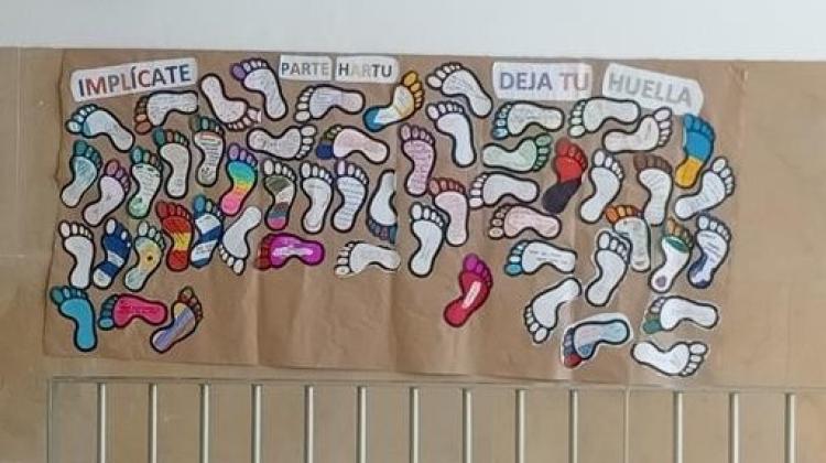 Un mural con huellas de pies pintadas bajo el título "deja tu huella"
